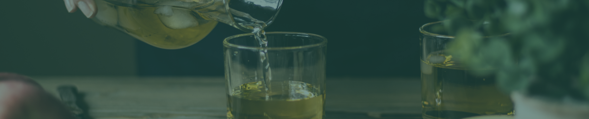  Pouring golden cider into a glass on a rustic table. 