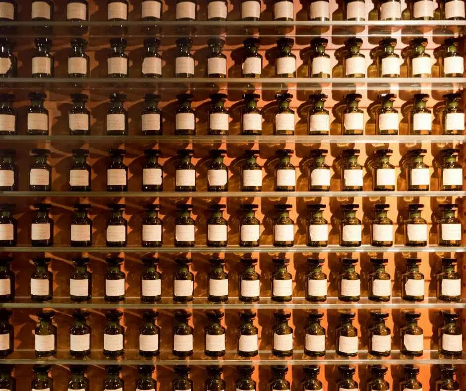 Wall of amber glass bottles filled with alcohol-based perfumes aligned in rows.